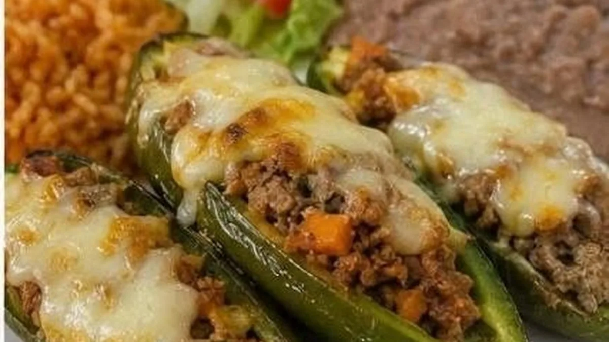 Chiles jalapenos rellenos de picadillo servidos con arroz y frijoles