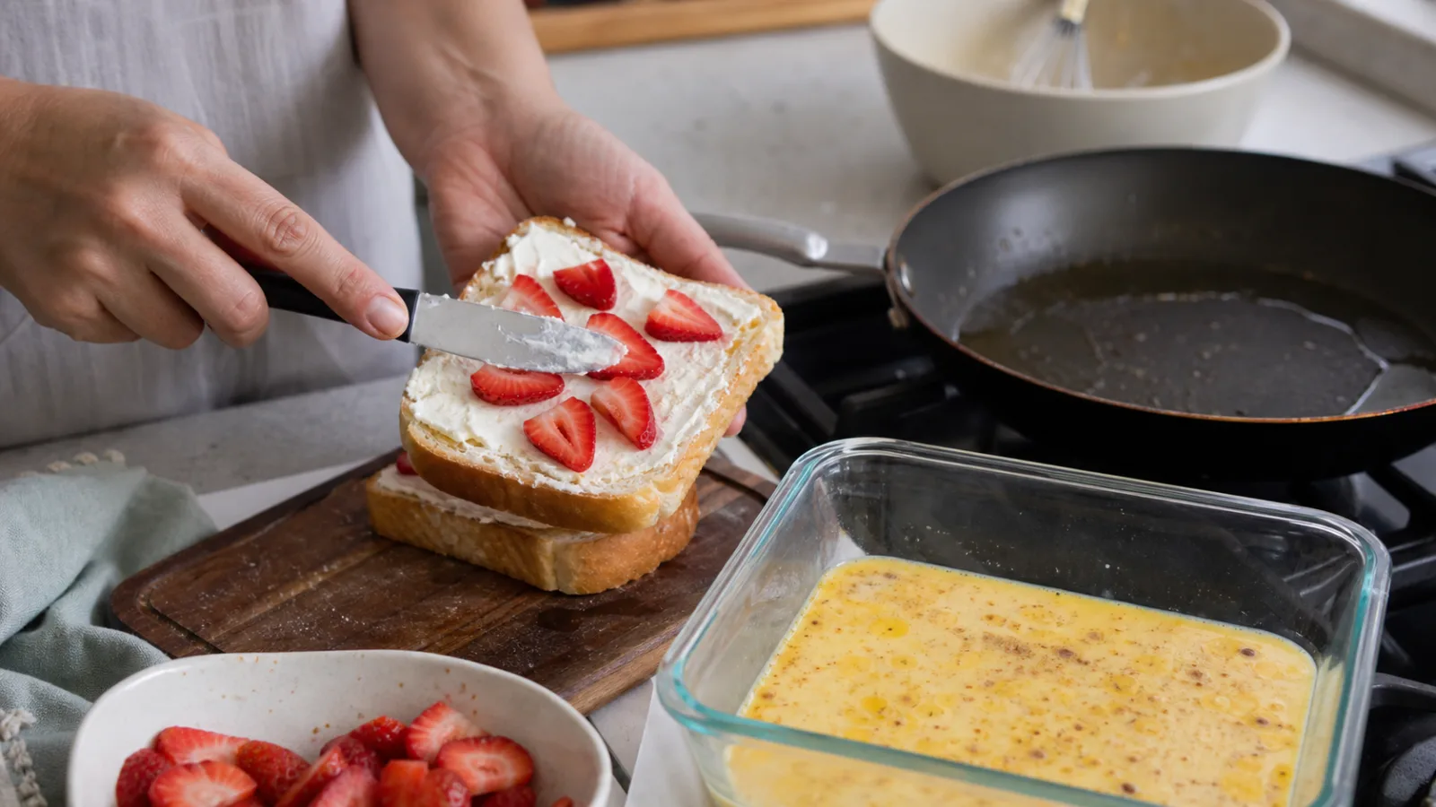 Preparacion casera de pan frances relleno con queso crema y fresas