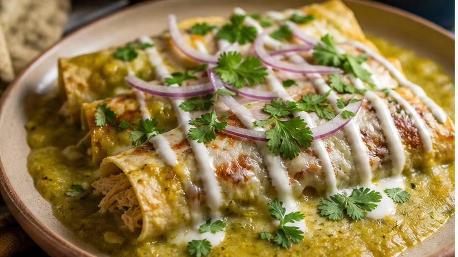 Enchiladas suizas verdes con pollo, salsa cremosa, queso gratinado, crema, cebolla morada y cilantro